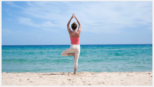 Photo of woman doing yoga pose on a beach