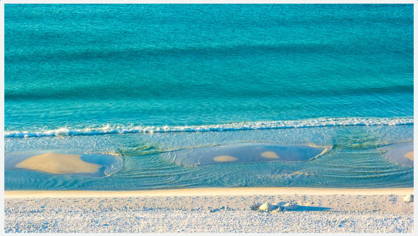 View of crystal blue water and sand on Florida beach