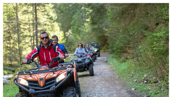 Image of people on ATVs riding on a dirt trail