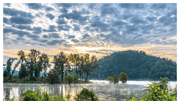 Image of sunrise and clouds over Broken Bow Lake