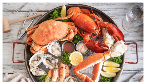 Top down view of a plate full of seafood with lemons and garnish