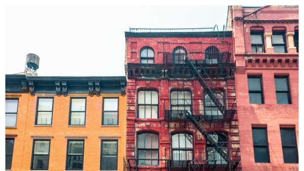 View of colorful NYC apartment buildings with a fire escape