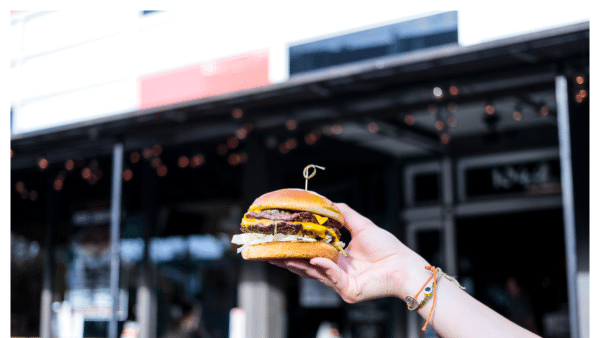 View of someone holding a burger from Bodega in Columbus OH