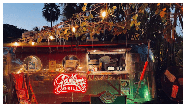 View of the Garbo's Grill food truck at night with neon sign