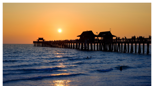 View of the Naples Florida pier at sunset with people fishing