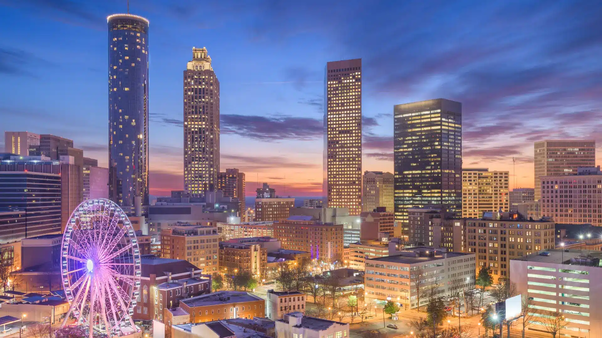 View of Atlanta skyline at dusk with a ferris wheel in the foreground